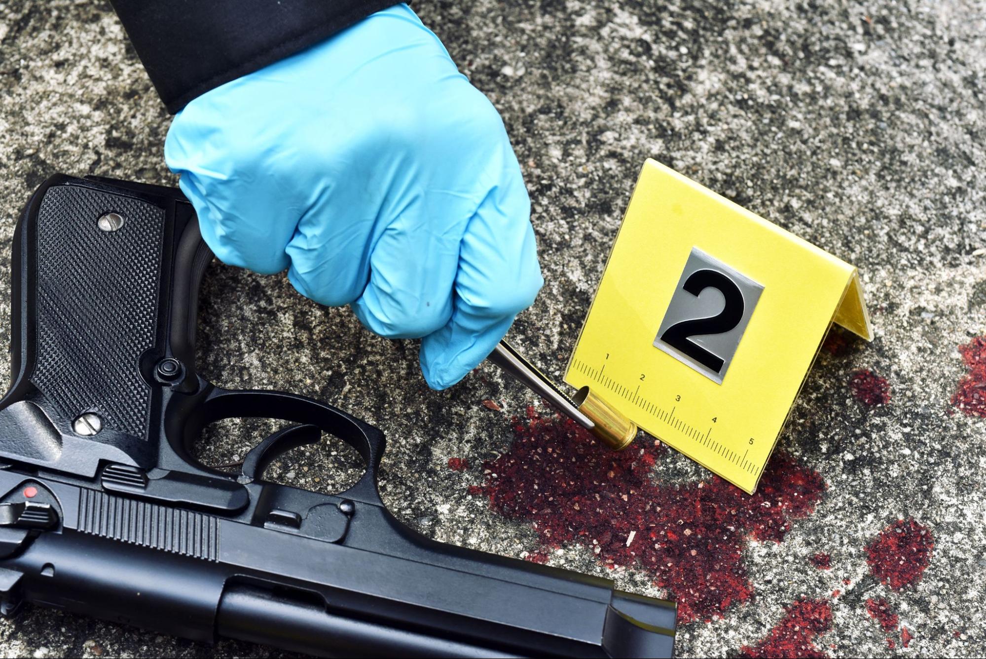 Law enforcement collects evidence, bullet casing at a crime scene.