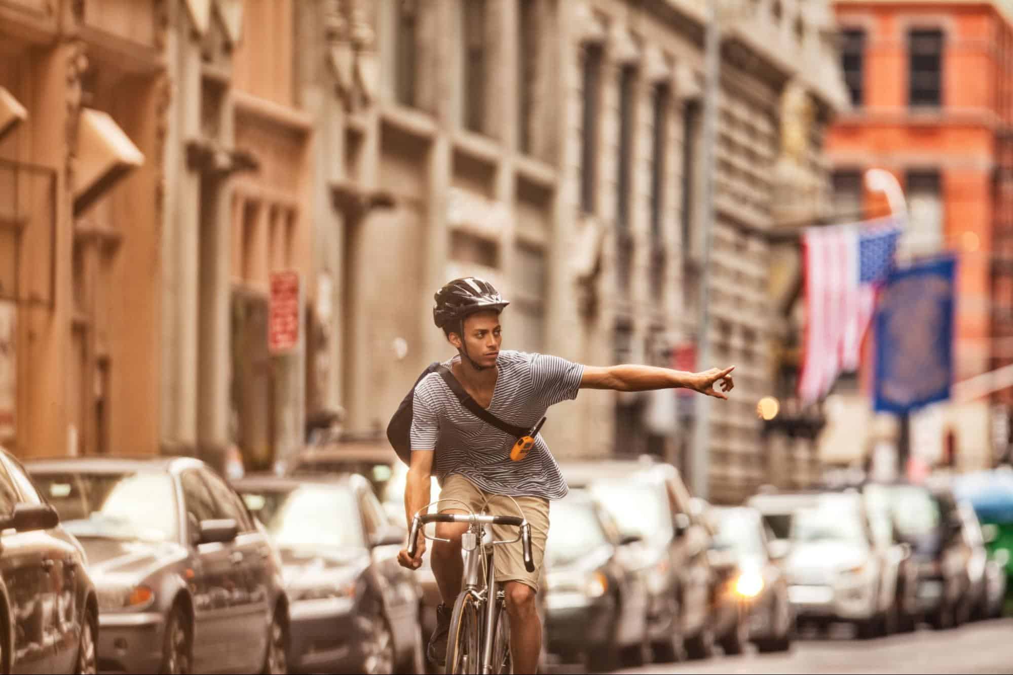 bicyclist making hand signal to turn representing new CA law AB 1909