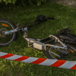 Defective foldable e-bike on grass with caution tape, representing an Amazon product liability lawsuit.