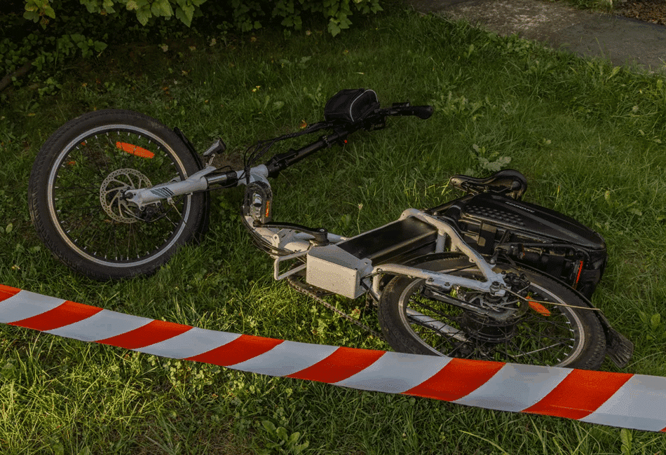 Defective foldable e-bike on grass with caution tape, representing an Amazon product liability lawsuit.