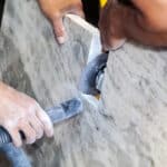 Worker grinding engineered stone countertop which may contain silicon