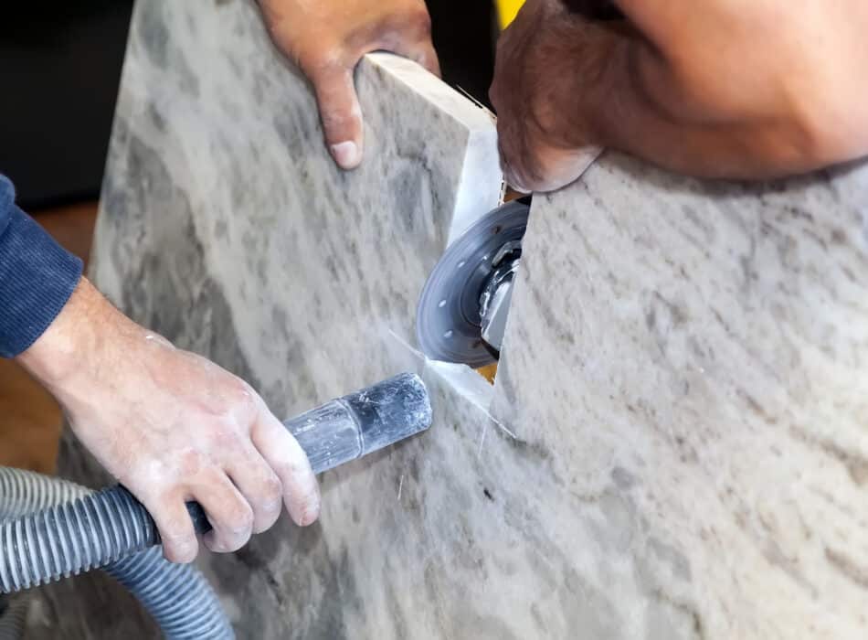 Worker grinding engineered stone countertop which may contain silicon
