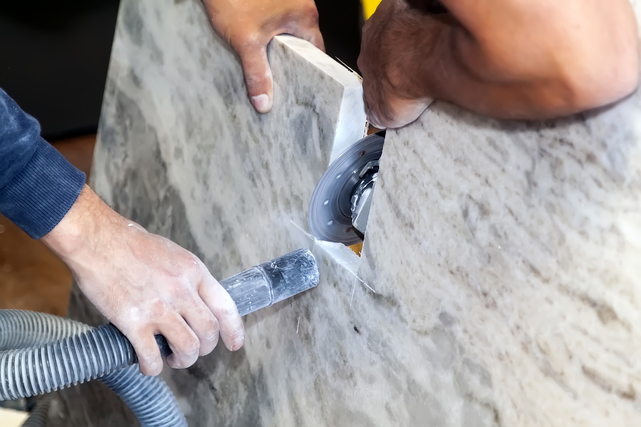 Worker grinding engineered stone countertop which may contain silicon